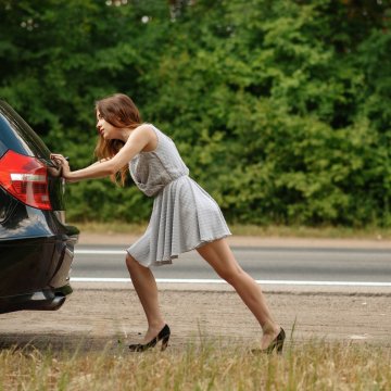 extended car warranty guide woman pushing car on the road